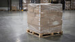 © Ame - A wooden pallet laden with stacked cardboard boxes wrapped in stretch film sits on a warehouse floor