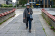 © GREGORIO - Senior woman walking in urban street setting