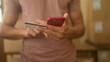 © Krakenimages.com - Man holding smartphone and creditcard tapping screen with fingers in building; small business focus determined.