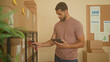 © Krakenimages.com - Man scanning cardboard packages with tablet and barcode scanner in a small business storage building; focus efficiency organization.