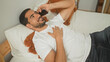 © Krakenimages.com - Man lying on bed holding smartphone to ear in bedroom, wearing white t shirt and jeans, hand on chest, occasionally resting arm behind head, smiling while talking; relaxed connection.