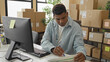 © Krakenimages.com - Man signing parcel form with pen and computer at desk in building surrounded by stacked cardboard boxes and shipping labels; efficiency focus.