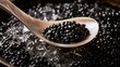 © 69 - Close-up view of black fish eggs on wooden spoon, detailed texture of shiny round caviar in dark rustic container for gourmet delicacy and luxury food concept