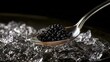 © 69 - Close up of black caviar on silver spoon over crushed ice with dark background for luxury food concept