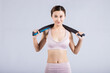 © HaMinh - Smiling young woman in sportswear resting with resistance band after workout