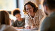 © Kateryna - Mid adult female teacher helping diverse high school students in a classroom european teacher cropped at the shoulders leaning over a desk pointing at a notebook multiethnic students seen