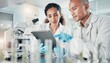 © David - Two laboratory scientists working with digital tablet while conducting medical research and analyzing clinical data in a modern biotechnology facility