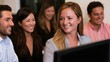 © Wuttichai - A group of professionals smiling while gathered around a computer screen in a modern office setting
