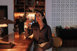 © Westend61 - Young businesswoman holds a drink at the hotel bar