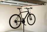 Bicycle maintenance and repair, black mountain bike mounted on a professional stand for tune up in a home garage workshop for cycling hobbyists