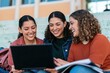 © Breezze - Students with a laptop sit on pale green stone campus steps, sharing a natural moment of digital learning for education and student-life campaigns