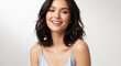 © Inspire Shots Hub - Portrait of a smiling woman with dark wavy hair and light blue dress, representing natural beauty and wellness