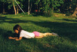 © Cara Dolan/Stocksy - Girl lying in a grassy field in summer