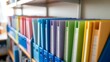 © MissJasmin - A Close-up Photograph of an Array of Colorful Document Binders Neatly Organized on Office Shelving Units for Efficient Filing