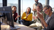 © CarlosBarquero - Diverse group of professionals applauding and celebrating together during an office meeting. Positive corporate scene conveying achievement, recognition, teamwork and shared success.