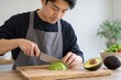 © Thi - man slicing avocado