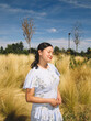 © Angel Santana/Stocksy - Young filipina woman relaxing in sunny meadow outdoors