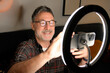© ADDICTIVE STOCK - Mature man use smartphone and ring light for remote work