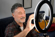 © ADDICTIVE STOCK - Mature man adjust smartphone camera for remote work video