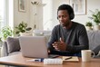 © Svetlana - Man using a laptop with headphones in a bright living room