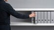 © BUBLY TUBLY - Business professional reaching for office binder for document management and archive organization in minimalist corporate workspace