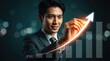 © Von - A confident Asian businessman is pointing to a rising arrow graph with a bright light effect. He is wearing a dark suit and tie, and he has a warm, friendly expression.