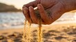 © Guilherme - Close up of hand holding sand pouring onto a beach at sunset