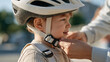 © AnastasiiaRozhmanova - Macro close up of a certified bicycle helmet buckle being fastened under a young child's chin by careful adult fingers, safety equipment, proper fit check, toddler cycling