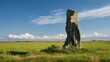 © Honey - Ancient weathered stone monolith standing tall against a clear blue sky, representing history, strength, and timeless landscape
