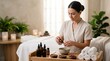 © Raphael - Spa treatment preparation: A female spa therapist carefully prepares essential oils for a massage therapy session, surrounded by calming decor and spa essentials, embodying tranquility and wellness.