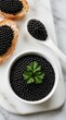 © Pete - Black caviar in white ceramic bowl with fresh parsley garnish. Gourmet sturgeon roe on crispy bread toast slices. Top view of expensive seafood delicacy on marble board. Luxury food appetizer for