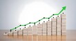 © Mujhid_Muneer - Business growth chart shown with wooden blocks stacked in ascending columns topped by green financial arrow pointing upwards