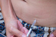 © leungchopan - Woman giving ivf hormone injection in belly with pen