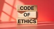 © John - Wooden blocks displaying code of ethics, integrity, compliance, accountability.