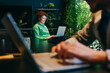 © BusinessClass by W61 - Smiling businesswoman working on laptop in modern green office