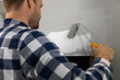 © ronstik - Handyman painting plaster patch with paint roller after wall repair