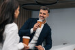 © Jelena - Business professionals enjoying coffee break and conversation