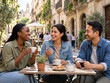 © Joan - Amigos viajeros conversando en un café al aire libre