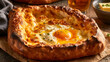 © Svetlana - Traditional Adjarian khachapuri, boat-shaped Georgian bread filled with melted cheese, egg yolk and butter, freshly baked and served hot.