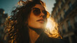 © Jack - Woman with wavy brown hair wearing sunglasses and a leather jacket outdoors