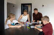 © ronstik - Happy family with two children playing drawing game together at home. Quality time