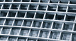 © Aleksandr Matveev - Metal grid with hexagonal patterns forms close-up view. Uniform cells create repeating geometric design. Smooth metallic surfaces reflect light subtly. Black and white tones highlight precision