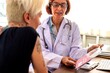 © Rawpixel.com - Doctor discussing a pamphlet with a patient in a medical office.
