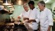 © SR07XC3 - Senior chefs training young cook in professional kitchen