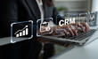 © InfiniteFlow - A business professional engaged with a laptop showcasing customer relationship management tools, data charts, and productivity icons in a sleek office environment. Nascent