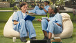 © DC Studio - Medical students in blue scrubs study on a campus lawn, using notebooks for collaborative outdoor learning as part of their healthcare training.