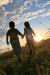 © yunda - Children holding hands walking in a grassy field at sunset