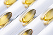 © Parilov - Macro golden softgel capsules arranged on conveyor for vitamin supplement packaging