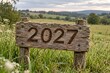 © ai image creator - Rustic wooden sign with carved year 2027 in a sunlit green countryside landscape