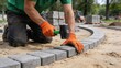 © FreemiumStock - Hardscape construction with rubber mallet and neat paving stones, showing manual labor and craftsmanship at active outdoor work site
